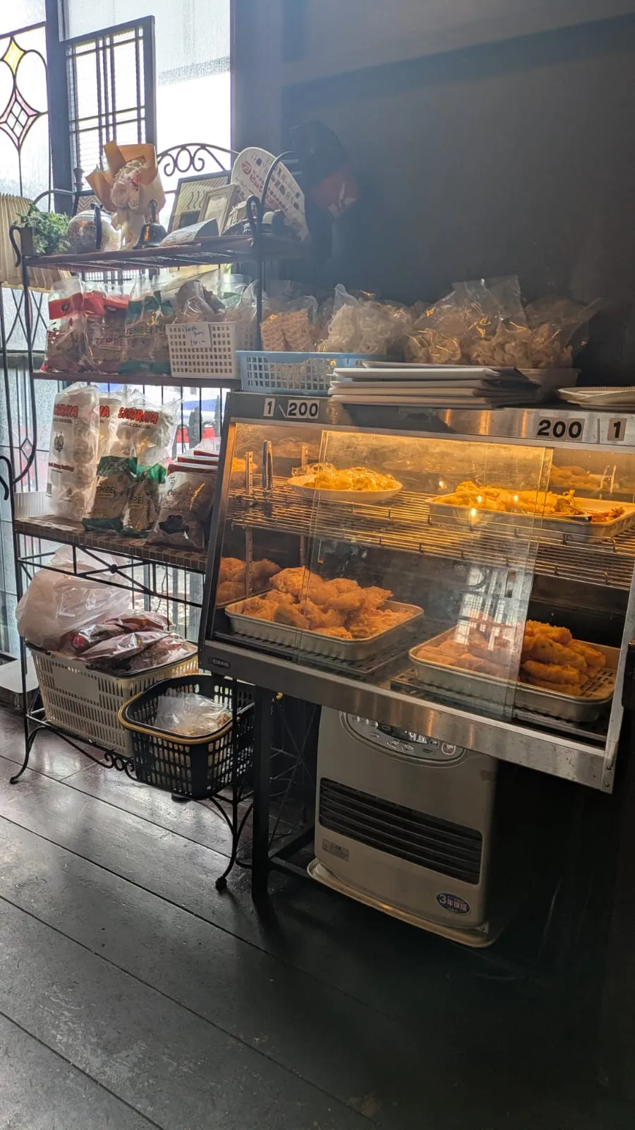 揚げ物のショーケースと、クルプックなどの乾物が並ぶ棚